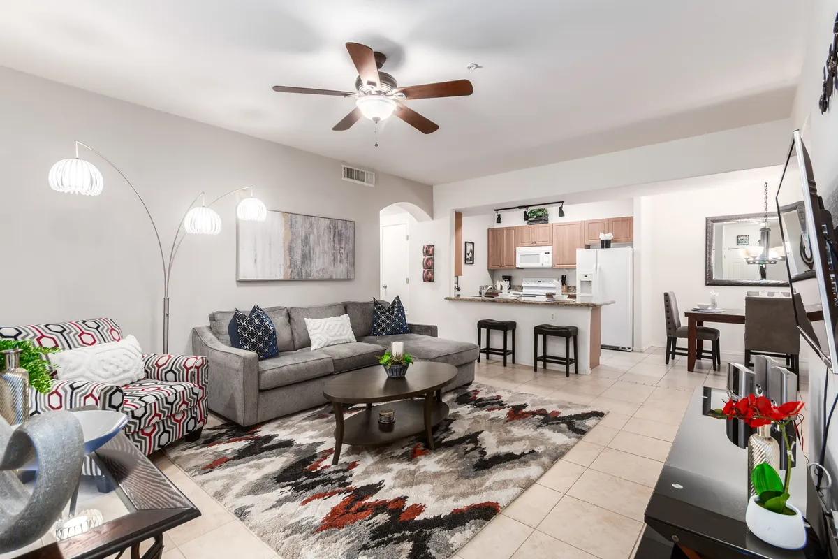 A spacious, inviting living space with a comfortable sofa, artistic wall décor, a coffee table, and an open kitchen area in the background. The layout suggests easy movement and social gatherings, with direct access to the ground-floor entry referenced in the section.